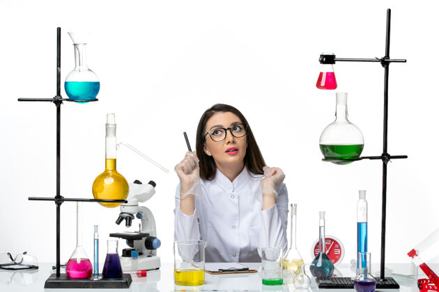 科学前视图穿着白色医疗服的女化学家正坐在白色地板上拿着解决方案科维-科学大流行实验室病毒成人西装病毒