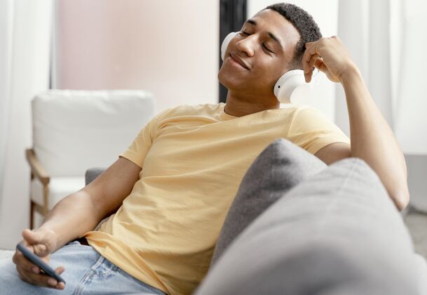 年轻肖像男在家放松 一边听音乐房子帅气耳机