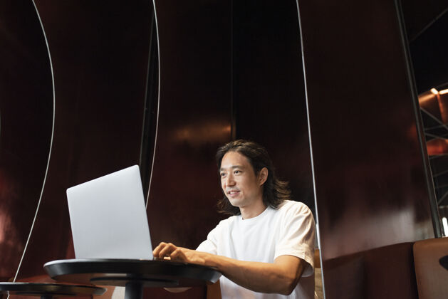 企业家男人在一个现代的办公空间里用笔记本电脑工作数字设备日本人新常态