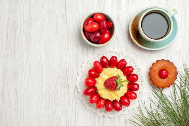 草药俯瞰白色桌子上的水果蛋糕和一杯茶甜点茶新鲜