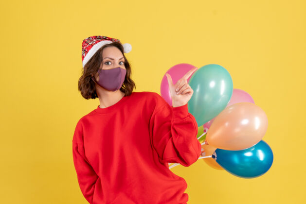 年正面图年轻女性隐藏在无菌面具气球圣诞节妇女节日色彩情感新年气球节日年轻女性