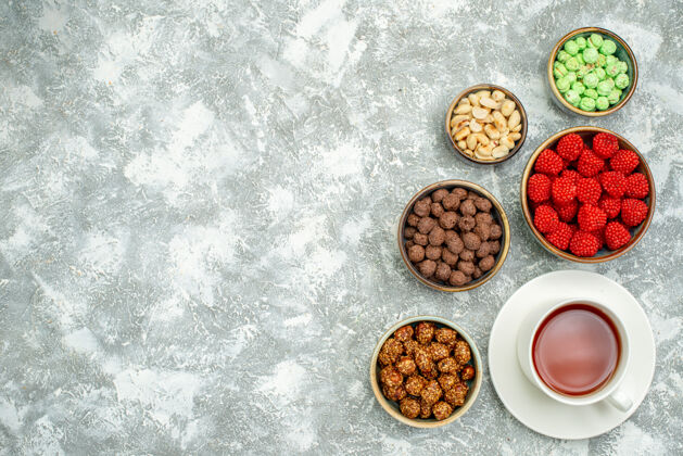 碗俯瞰美味的甜糖果和坚果和一杯茶的白色空间美味生的茶