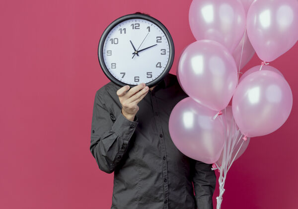 抱着男人站在那里 手里拿着氦气球 脸被隔离在粉红色的墙上站着氦生日