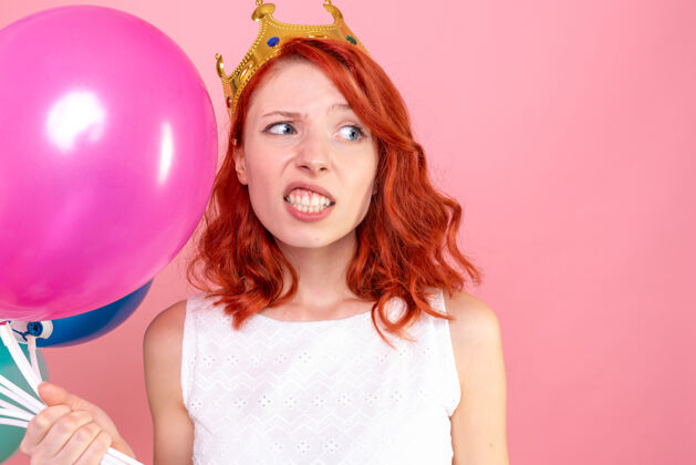 美丽前方近景年轻女子手持五颜六色的气球上粉红色气球可爱肖像