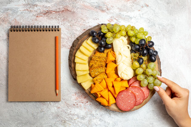 水果顶视图不同的小吃cips香肠奶酪和新鲜葡萄在白色空间新鲜葡萄食品