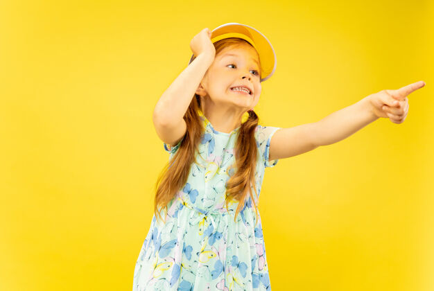 情绪美丽动情的小女孩被隔离在黄色的背景上半幅快乐的孩子的肖像 穿着裙子 戴着橙色的帽子夏天的概念 人类的情感 童年美丽度假村微笑