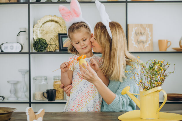 室内妈妈和女儿一起在厨房拿着复活节彩蛋母亲帮助快乐