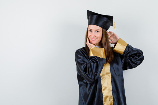 肖像年轻的女毕业生站着 穿着学院服 看起来很迷人正面图姿势前面健康