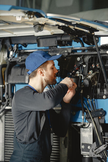修理汽车修理工在车库里用工具修理蓝色的汽车车辆人车间
