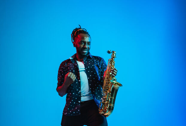 著名年轻的非洲裔美国爵士乐音乐家在演奏萨克斯管灯光蓝调城市