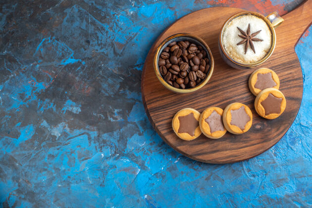 杯子侧面特写镜头糖果饼干咖啡豆一杯咖啡放在木板上勺子香料咖啡