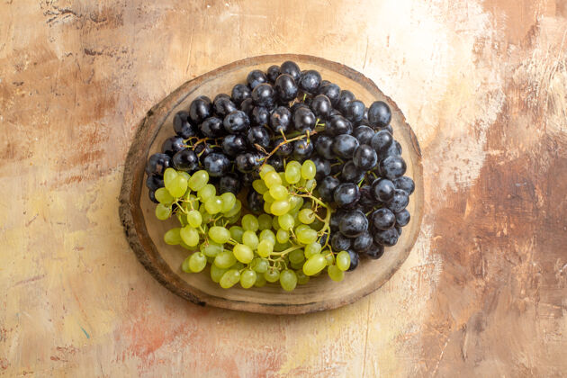 食物顶视图葡萄串绿色和黑色的葡萄在厨房板上浆果葡萄美味