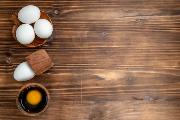 早餐顶视图生鸡蛋全产品上一个棕色背景鸡蛋食物餐早餐午餐面包健康顶部午餐鸡蛋