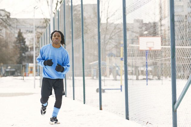 人冬天公园里的男人在外面训练的非洲男人男人跑活跃教练动作
