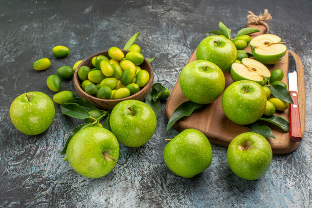 壁板侧面特写查看苹果绿色苹果与树叶板上的一碗柑橘类水果特写健康柠檬