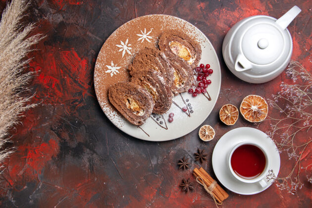 茶俯瞰美味饼干卷和一杯茶在黑暗的桌子上营养品蛋糕派
