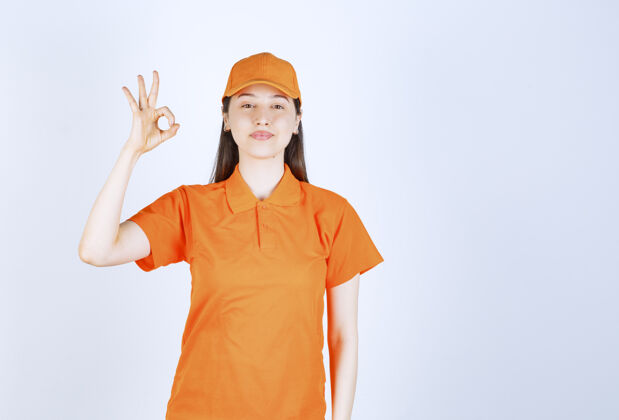夏天女服务人员穿着橙色制服 手上有积极的手势女人工人雇员