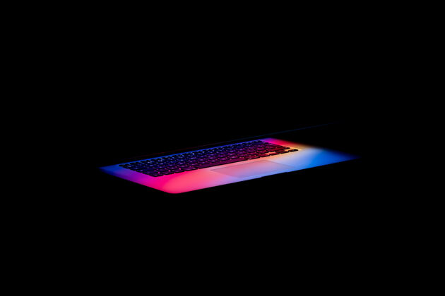 现代五颜六色的光从黑暗中的笔记本电脑屏幕出来光明电脑网络