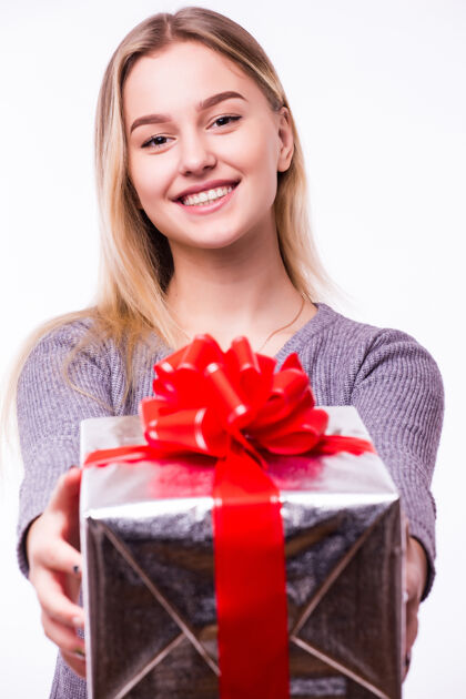 年轻年轻漂亮的女孩带着礼物被隔离在白墙上微笑购物女人