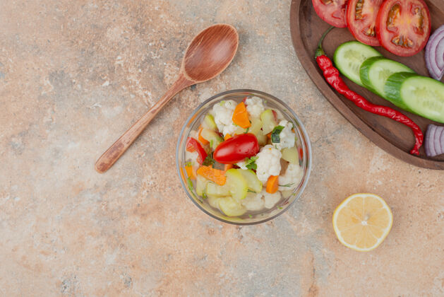 美味美味的蔬菜放在玻璃盘上 番茄 黄瓜和洋葱的木板放在大理石上西红柿胡萝卜蔬菜