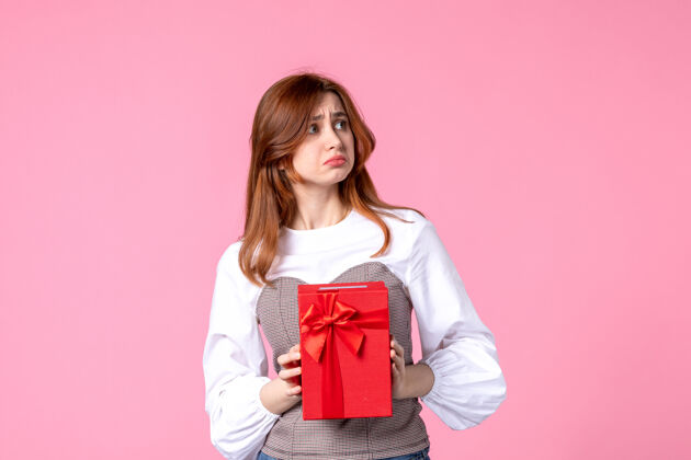 年轻女性正面图：年轻女性 粉色背景 红色包装 三月横向性感礼物 香水 照片 金钱女人礼品礼品包装