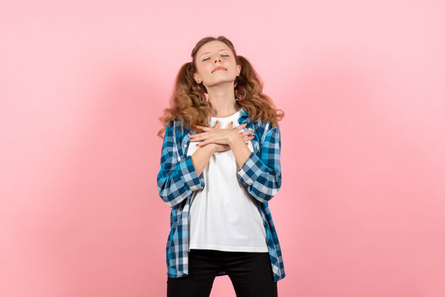 头发正面图：穿着格子衬衫的年轻女性在粉色背景上摆姿势模特女性情感儿童青春色彩肖像姿势微笑
