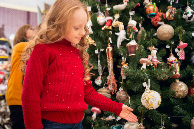 选择圣诞树微笑的家人 妈妈和孩子在家里的商店里寻找家庭装饰和节日礼物时尚复古的问候或设计的东西室内装修 庆祝时间搜索女人圣诞节