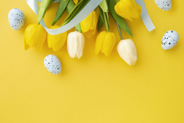 复活节背景用郁金香和逾越节彩蛋做成的复活节彩画 背景为黄色 有复制空间雏菊复制空间花