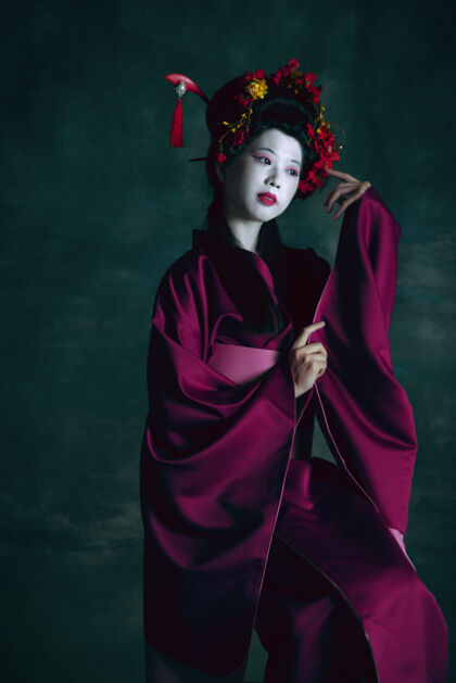 巴洛克梦幻年轻的日本女人像艺妓一样孤立在深绿色的墙上复古的风格 比较时代的概念漂亮的女模特喜欢鲜明的历史人物 老式的比较日本年龄