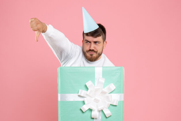 展台正面图：年轻男性站在礼物盒内 参加粉色圣诞照片彩色情感睡衣派对颜色正面礼物