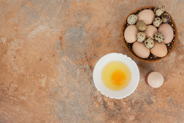 食物大理石桌上的盘子上有几个鸡蛋和生鸡蛋鸡蛋蛋黄蛋白质