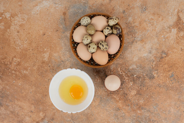 鸡蛋大理石桌上的盘子上有几个鸡蛋和生鸡蛋美味蛋白质食物