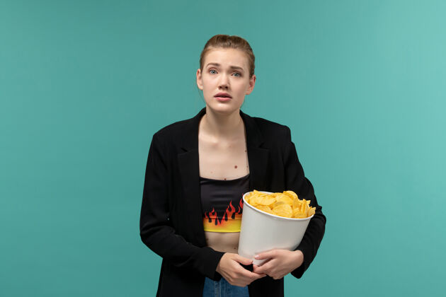 服务员正面图年轻的女性在蓝色的水面上吃薯片看电影年轻的女性前面雇员