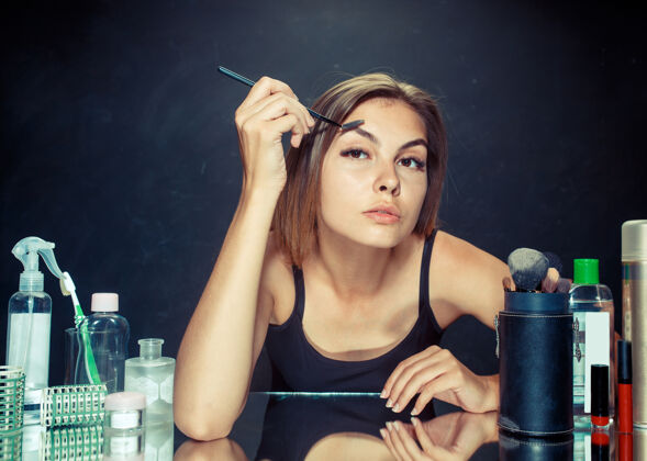 深色美女化妆美女照镜子 用大刷子化妆早上好 化妆和人类情感概念头发情绪应用