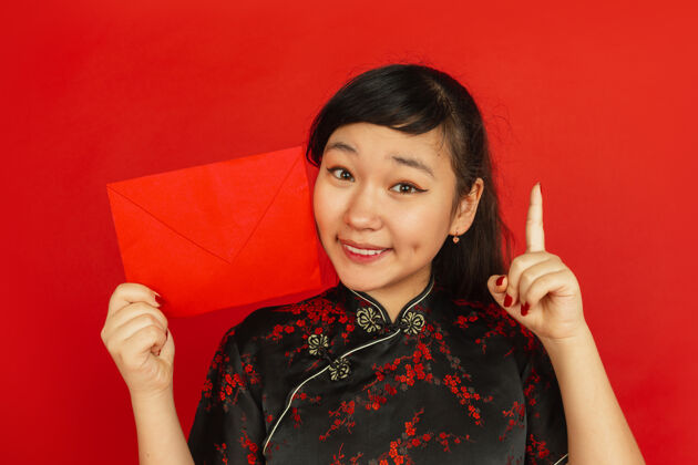 服饰带着红包的年轻亚洲女人节日肖像中国