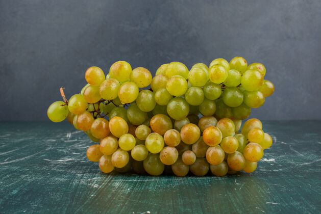成熟大理石桌上放着一束绿葡萄葡萄水果天然