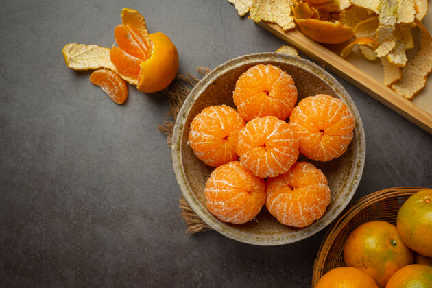 冬季在旧的深色背景上剥橘子核桃杏仁配料