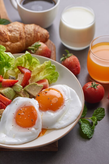 新鲜美味的早餐 供应新鲜的牛角面包和咖啡 牛奶 橙汁绿色菠菜膳食