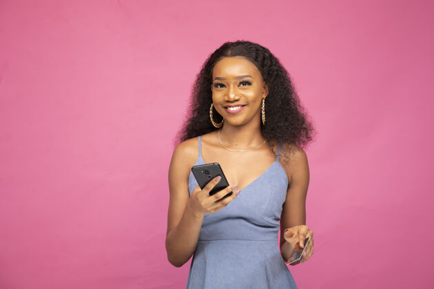 支付年轻的非洲女性使用智能手机和信用卡在线购物支付信贷移动