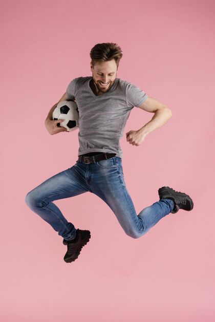 肖像一个拿着足球的男人跳跃模特足球