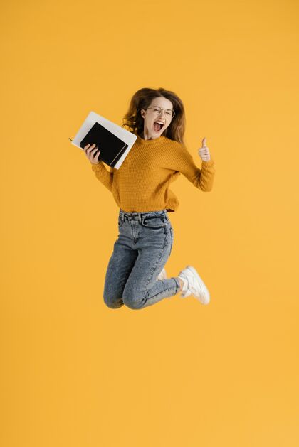 肖像一幅年轻女子跳着拿着书的画像议程跳跃女人