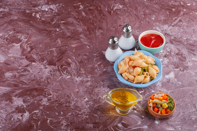 美味意大利贝壳面食配番茄酱和混合蔬菜沙拉 放在浅色桌上贝壳烹饪饮食