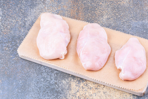 营养把鸡胸肉放在木板上 放在大理石桌上美味膳食烹饪