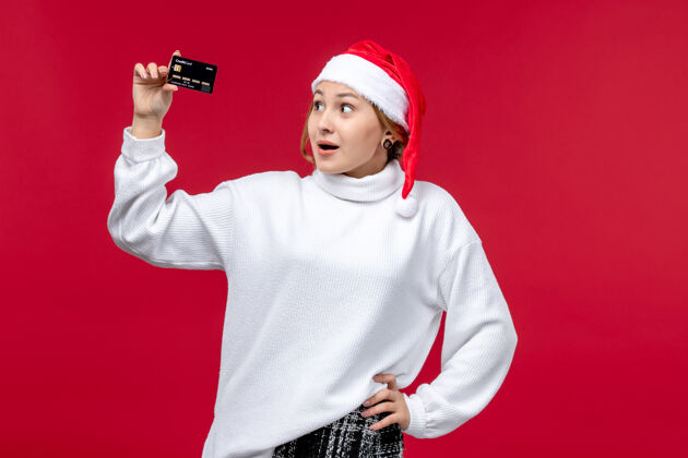 人正面图 年轻女子手持红色背景的银行卡卡片礼物成人