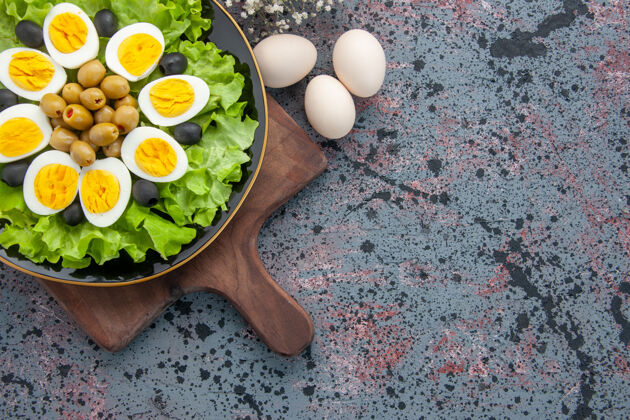 蔬菜俯瞰美味的煮蛋 绿色沙拉和橄榄在浅色背景下光沙拉食物