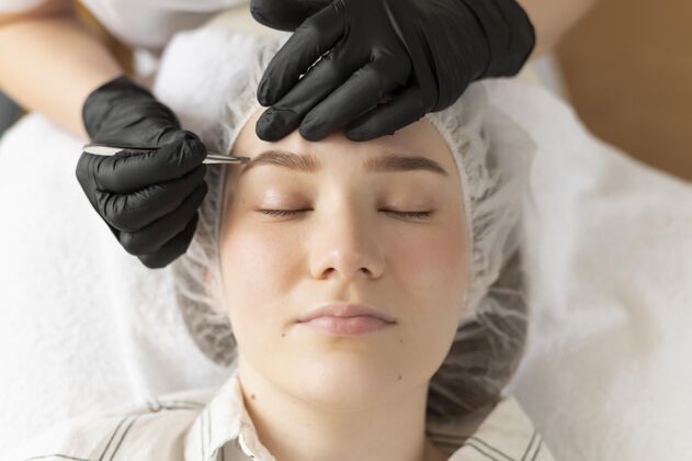 美容在美容院修眉毛的年轻女人过程治疗护理