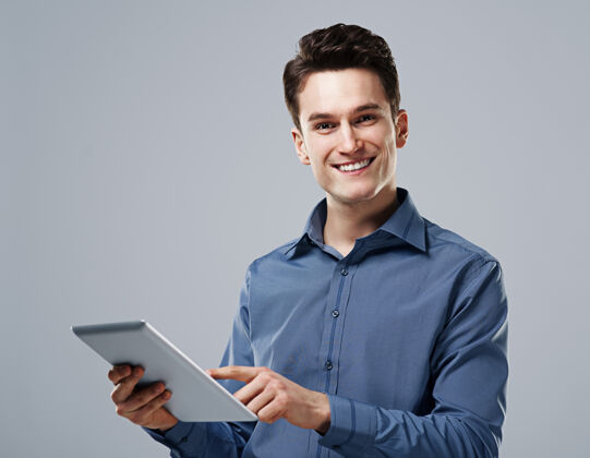 年轻人使用数字平板电脑的快乐男人工作触摸模切
