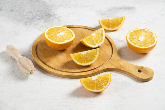 天然用木铰刀在大理石上切鲜橙子黄色木材新鲜