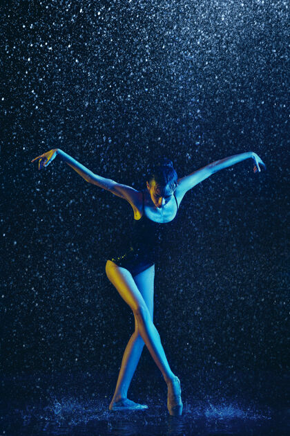 水年轻的女芭蕾舞演员在水滴和浪花下表演白种人模特在霓虹灯下跳舞迷人的女人芭蕾舞和当代舞蹈概念赤脚舞蹈现代