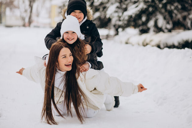 妈妈妈妈带着女儿和儿子在满是雪的公园里玩冬装儿子快乐